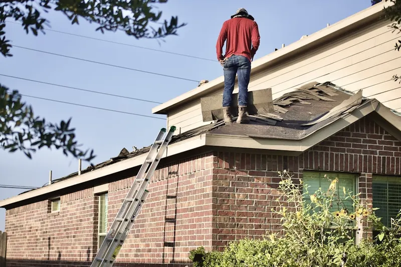 Professional roofer working on a residential roof in Coalinga